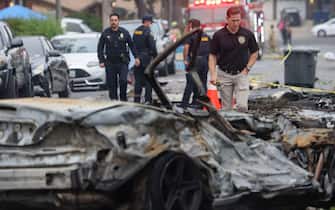 San Diego Investigators look through the site where a small plane crashed into a San Diego, California, residential street on May 22, 2025. The Federal Aviation Authority said a Cessna 550 crashed at around 3:45 am local time. The neighborhood is close to the Montgomery-Gibbs Executive Airport. The crash left a "gigantic debris field" and damaged some 15 homes and parked cars, ABC News quoted the San Diego assistant fire chief as saying. (Photo by Sandy Huffaker / AFP)