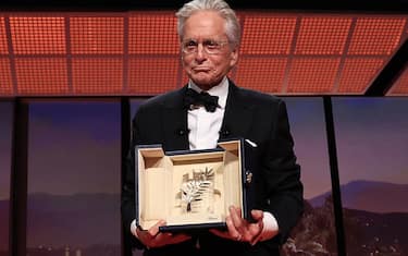 US actor Michael Douglas holds up the Honorary Palme d'or of he 76th Cannes Film Festival he received during the opening ceremony in Cannes, southern France, on May 16, 2023. (Photo by Valery HACHE / AFP) (Photo by VALERY HACHE/AFP via Getty Images)