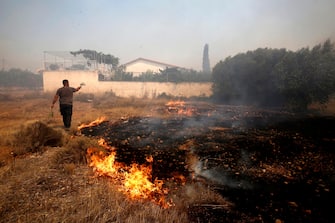 epa10751680 A man battles a wildfire raging at Lagonisi area, Greece, 17 July 2023. Firefighting forces are battling a blaze that broke out in the Kouvaras area in Attica, while a warning was sent via the emergency number 112 to evacuate several settlements in southeast Attica. A force of 55 firefighters and 20 fire engines, two units on foot and 31 Romanian firefighters with five water tankers have been deployed to put out the fire, assisted by six fire-fighting aircraft and four helicopters from the air.  EPA/YANNIS KOLESIDIS
