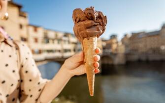 Holding chocolate ice cream on background of Florence, Italy