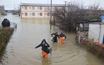 TOPSHOT - Local residents are seen evacuated from the flooded village of Pribrezhnoe in Crimea on November 27, 2023, following a storm. Over 400,000 people in Crimea were left without power on November 27, 2023 after hurricane force winds and heavy rains battered the Russian-annexed peninsula over the weekend. Wind speeds of more than 140 kilometres per hour (about 90 mph) were recorded during the storm, which triggered a state of emergency in some of the peninsula's municipalities. (Photo by STRINGER / AFP) (Photo by STRINGER/AFP via Getty Images)