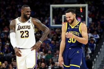 SAN FRANCISCO, CALIFORNIA - JANUARY 27: LeBron James #23 of the Los Angeles Lakers and Stephen Curry #30 of the Golden State Warriors make each other laugh during a stop in play in the first half at Chase Center on January 27, 2024 in San Francisco, California. NOTE TO USER: User expressly acknowledges and agrees that, by downloading and or using this photograph, User is consenting to the terms and conditions of the Getty Images License Agreement.  (Photo by Ezra Shaw/Getty Images)