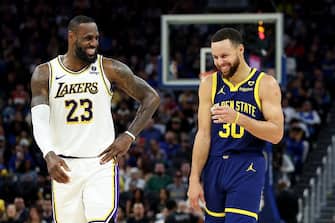 SAN FRANCISCO, CALIFORNIA - JANUARY 27: LeBron James #23 of the Los Angeles Lakers and Stephen Curry #30 of the Golden State Warriors make each other laugh during a stop in play in the first half at Chase Center on January 27, 2024 in San Francisco, California. NOTE TO USER: User expressly acknowledges and agrees that, by downloading and or using this photograph, User is consenting to the terms and conditions of the Getty Images License Agreement.  (Photo by Ezra Shaw/Getty Images)