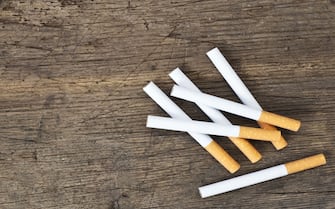 Cigarettes lying on wooden board.