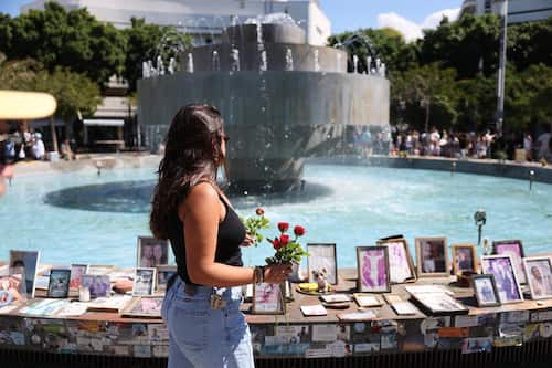 epa12436461 People laying flowers near pictures and memorials of Israeli victims of the October 7th attack at the fountain of Dizengoff Square in Tel Aviv, Israel, 07 October 2025. October 07 marks two years since the Palestinian militant group Hamas launched a surprise attack on Israel, taking dozens of hostages and killing nearly 1,200 people. In response, Israel began its war on Gaza, which has killed more than 66,000 people, displaced millions and destroyed the Palestinians enclave.  EPA/ABIR SULTAN