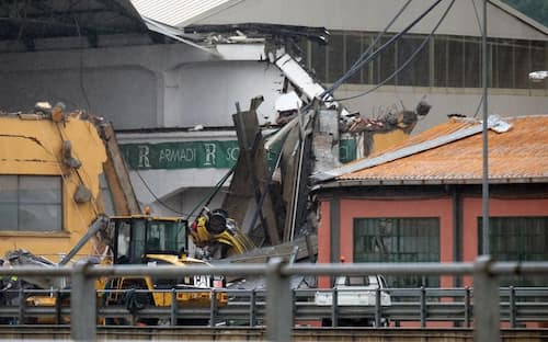 Rescuers are at work amid the rubble of a section of a giant motorway bridge that collapsed earlier, on August 14, 2018 in Genoa. - Rescuers scouring through the wreckage after part of a viaduct of the A10 freeway collapsed said there were "tens of victims", while images from the scene showed an entire carriageway plunged on to railway lines below. (Photo by ANDREA LEONI / AFP)        (Photo credit should read ANDREA LEONI/AFP via Getty Images)