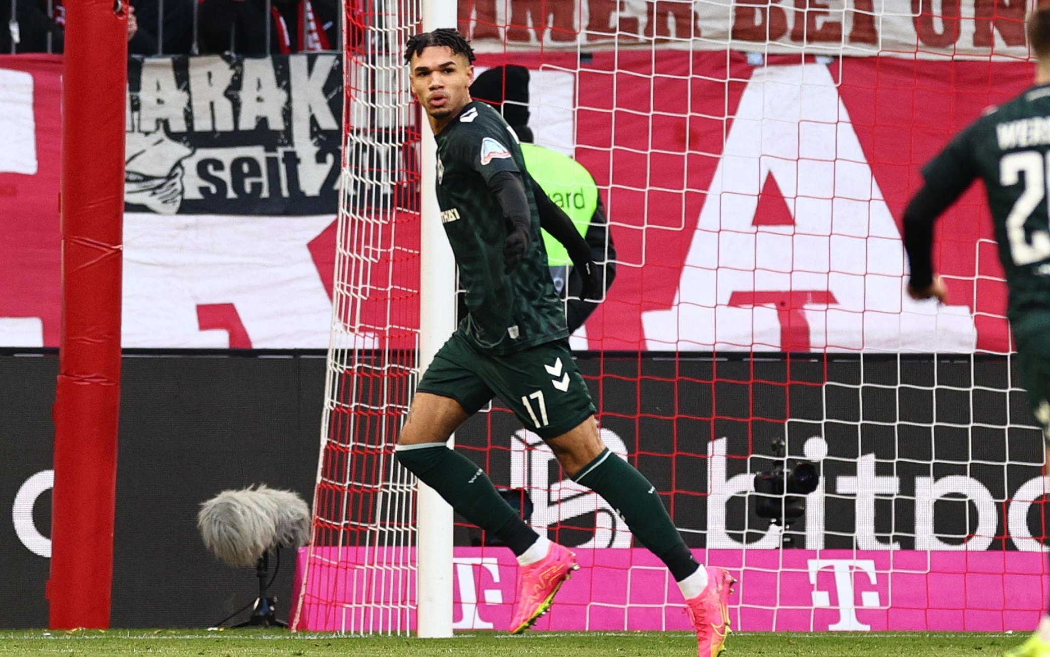 epa11094303 Bremen s Justin Njinmah (L) celebrates with teammate Bremen s Romano Schmid (R) after scoring a goal that was later dissolved during the German Bundesliga soccer match between FC Bayern Munich and Werder Bremen in Munich, Germany, 21 January 2024.  EPA/ANNA SZILAGYI CONDITIONS - ATTENTION: The DFL regulations prohibit any use of photographs as image sequences and/or quasi-video.