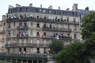 PARIS, FRANCE - JULY 26: Spectators look on from windows and balconies during the opening ceremony of the Olympic Games Paris 2024 on July 26, 2024 in Paris, France. (Photo by Naomi Baker / POOL / AFP) (Photo by NAOMI BAKER/POOL/AFP via Getty Images)