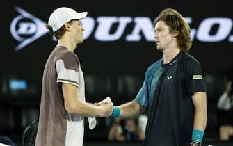 epa11098808 Jannik Sinner of Italy (L) shakes hands with Andrey Rublev of Russia (R) after winning his quarterfinal match at the Australian Open tennis tournament in Melbourne, Australia, 23 January 2024.  EPA/MAST IRHAM