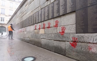 A city employee is at work to clean the "Wall of the Righteous" (Mur des Justes) covered with Red hands graffitis outside the Shoah memorial in Paris, on May 14, 2024, after the monument was vandalized overnight with the president of the Representative Council of French Jewish Institutions (CRIF) denouncing the act as antisemitic. (Photo by Antonin UTZ / AFP) (Photo by ANTONIN UTZ/AFP via Getty Images)