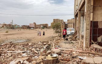 People walk near the rubble at a house that was hit by an artillery shell in the Azhari district in the south of Khartoum on June 6, 2023. The United States and Saudi Arabia on June 4 made a renewed push for truce talks between Sudan's warring generals as deadly fighting has raged into its eighth week. Multiple ceasefires have been agreed and broken, and Washington slapped sanctions on the two warring generals last week, blaming both sides for the "appalling" bloodshed. (Photo by AFP) (Photo by -/AFP via Getty Images)