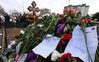 Election ballot papers are seen left on the grave of late Russian opposition leader Alexei Navalny at the Borisovo cemetery in Moscow on March 17, 2024, the final day of voting in the three-day Russia's presidential election. (Photo by NATALIA KOLESNIKOVA / AFP)