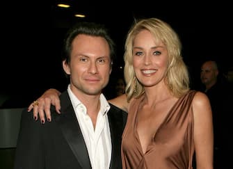 LOS ANGELES, CA - NOVEMBER 21:  (EXCLUSIVE ACCESS)  Actor Christian Slater (left) and actress Sharon Stone pose backstage at the 2006 American Music Awards held at the Shrine Auditorium on November 21, 2006 in Los Angeles, California.  (Photo by Michael Buckner/AMA/Getty Images for AMA)