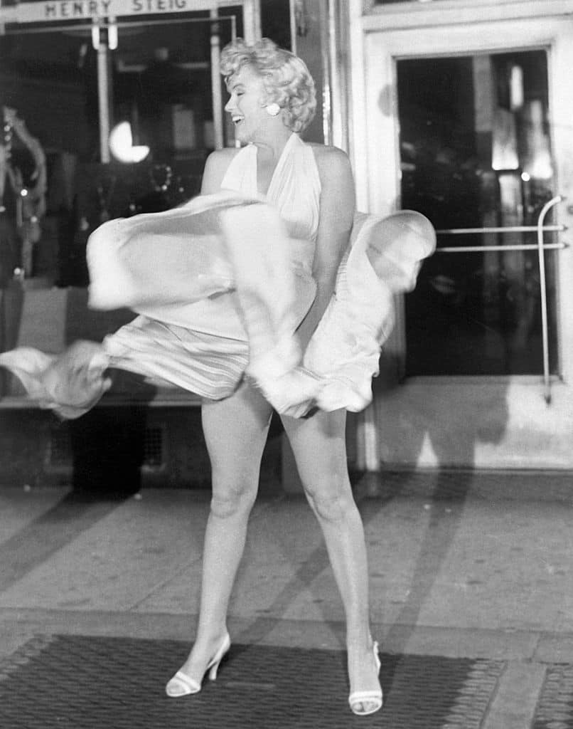 Actress Marilyn Monroe tries to hold down her dress as wind from a subway grate blows it upward during filming of The Seven Year Itch motion picture in Manhattan.