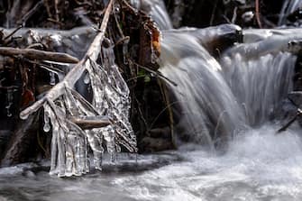 epa10548498 Twigs encrusted with ice hang above a stream near salgotarjan, northern Hungary, 29 March 2023, when subzero temperatures were recorded overnight in most parts of the country.  EPA/Peter Komka HUNGARY OUT