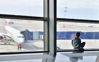 Moscow, Russia - April 4. 2018. child through window looks at plane in airport Vnukovo
