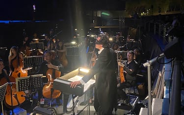 Il maestro Alberto Veronesi con una benda calata sugli occhi dirige la Boheme in allestimento ambientato nel '68, con Mimì in minigonna e altri richiami alla contestazione giovanile nell'ambito del 69/o Festival Pucciniano di Torre del Lago (Lucca), 14 luglio 2023. ANSA/ ROY LEPORE