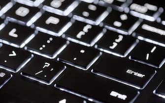 Backlit computer keyboard, technological black and white background, close-up of illuminated keyboard.