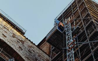 Perugia -BONUS FACCIATE - il centro storico in fermento ,completamente occupato dai cantieri edili per la ristrutturazione e il restauro delle facciate dei palazzi promosse dal bonus facciate e dall' Art bonus . le impalcature e i teli di abbellimento stravolgono l'aspetto delle vie e delle piazze . Arco di Maestà delle Volte, una squadra lavora al consolidamento delle impalcature . (Perugia - 2022-01-28, Bianconi Emanuela) p.s. la foto e' utilizzabile nel rispetto del contesto in cui e' stata scattata, e senza intento diffamatorio del decoro delle persone rappresentate