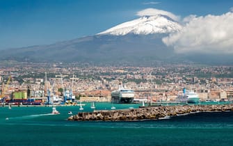 View of Mount Etna, City, and Port, Catania, Sicily, Italy. Catania sits at the foot of Mt. Etna, an active volcano.