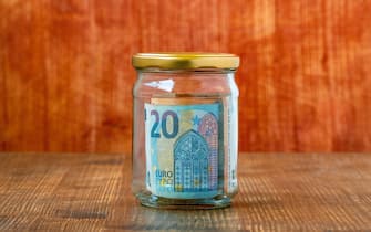Money saving in glass jar with Euros inside