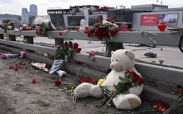 Flowers and toys are seen left at the side of a road near the burnt-out Crocus City Hall concert venue in Krasnogorsk, outside Moscow, on March 26, 2024. At least 139 people were killed when gunmen in camouflage stormed Crocus City Hall, shooting spectators before setting the building on fire in the most fatal attack in Europe to have been claimed by Islamic State jihadists. (Photo by NATALIA KOLESNIKOVA / AFP)