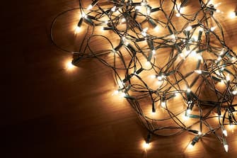Traditional Christmas Tree lights lying on a wooden floor.