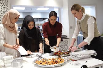 LONDON, ENGLAND - NOVEMBER 21: Meghan, Duchess of Sussex with chef Clare Smyth (R) and kitchen co-ordinator Zaheera Sufyaan (2L) as she visits the Hubb Community Kitchen to see how funds raised by the 'Together: Our Community' Cookbook are making a difference at Al Manaar, North Kensington on November 21, 2018 in London, England. (Photo by Chris Jackson/Getty Images)