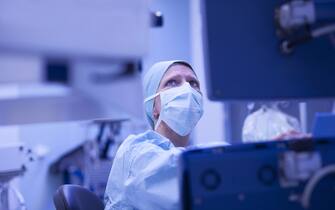 Anesthetist checking  parameters gaz  and bloodstream of external heart on monitor during open heart surgery.