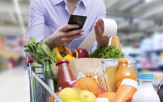 Woman checking the grocery receipt using her smartphone