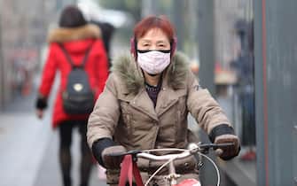 epa08143671 A Chinese cyclist is seen with a mask while riding past a bus station near the closed Huanan Seafood Wholesale Market, which has been linked to cases of a new strain of Coronavirus identified as the cause of the pneumonia outbreak in Wuhan, Hubei province, China, 20 January 2020. China reported on 20 January an additional death and surge of 139 new confirmed cases of the mysterious SARS-like virus linked to the Wuhan pneumonia outbreak, bringing the total number of cases to 198 with three deaths so far.  EPA/STR CHINA OUT