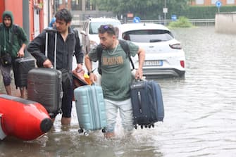 Alcuni residenti evacuano le loro abitazioni nel quartiere di Ponte Lambro, alla porte di Milano, 15 maggio 2024. ANSA/PAOLO SALMOIRAGO