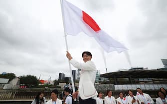 PARIS, FRANCE - JULY 26: Nakarai Shigeyuki, known as B-Boy Shigekix, Flagbearer of Team Japan,waves Japan flag during the athletesâ   parade on the River Seine  during the opening ceremony of the Olympic Games Paris 2024 on July 26, 2024 in Paris, France. (Photo by Michael Reaves/Getty Images)