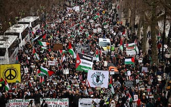 Pro-Palestinian activists and supporters wave flags and carry placards during a National March for Palestine in central London on January 13, 2024. Hamas's unprecedented attack on Israel on October 7, 2023 which left about 1,140 dead in Israel, mostly civilians, according to an AFP tally based on official figures, and saw 250 hostages dragged back into Gaza sparked the war which is still raging in the besieged Gaza Strip. After almost 100 days of war, at least 23,357 people have been killed in the fighting, the majority of them women and children, according to the Hamas health ministry -- or almost one percent of the population. (Photo by HENRY NICHOLLS / AFP)