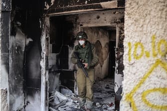10 October 2023, Israel, Kfar Aza: An Israeli soldier inspects a destroyed house as fighting between Israeli troops and Islamist Hamas militants continues. Photo: Ilia Yefimovich/dpa (Photo by Ilia Yefimovich/picture alliance via Getty Images)