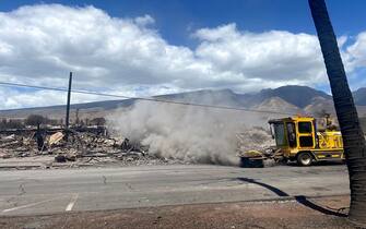 A truck sweeps a street next to destroyed buidlings in the aftermath of a wildfire in Lahaina, western Maui, Hawaii on August 11, 2023. A wildfire that left Lahaina in charred ruins has killed at least 55 people, authorities said on August 10, making it one of the deadliest disasters in the US state's history. Brushfires on Maui, fueled by high winds from Hurricane Dora passing to the south of Hawaii, broke out August 8 and rapidly engulfed Lahaina. (Photo by Paula RAMON / AFP) / "The erroneous mention[s] appearing in the metadata of this photo by Paula RAMON has been modified in AFP systems in the following manner: [August 11] instead of [August 10]. Please immediately remove the erroneous mention[s] from all your online services and delete it (them) from your servers. If you have been authorized by AFP to distribute it (them) to third parties, please ensure that the same actions are carried out by them. Failure to promptly comply with these instructions will entail liability on your part for any continued or post notification usage. Therefore we thank you very much for all your attention and prompt action. We are sorry for the inconvenience this notification may cause and remain at your disposal for any further information you may require." (Photo by PAULA RAMON/AFP via Getty Images)