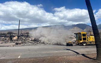 A truck sweeps a street next to destroyed buidlings in the aftermath of a wildfire in Lahaina, western Maui, Hawaii on August 11, 2023. A wildfire that left Lahaina in charred ruins has killed at least 55 people, authorities said on August 10, making it one of the deadliest disasters in the US state's history. Brushfires on Maui, fueled by high winds from Hurricane Dora passing to the south of Hawaii, broke out August 8 and rapidly engulfed Lahaina. (Photo by Paula RAMON / AFP) / "The erroneous mention[s] appearing in the metadata of this photo by Paula RAMON has been modified in AFP systems in the following manner: [August 11] instead of [August 10]. Please immediately remove the erroneous mention[s] from all your online services and delete it (them) from your servers. If you have been authorized by AFP to distribute it (them) to third parties, please ensure that the same actions are carried out by them. Failure to promptly comply with these instructions will entail liability on your part for any continued or post notification usage. Therefore we thank you very much for all your attention and prompt action. We are sorry for the inconvenience this notification may cause and remain at your disposal for any further information you may require." (Photo by PAULA RAMON/AFP via Getty Images)