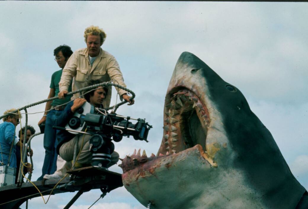 Director Steven Spielberg, kneeling with camera, during production of Jaws (1975). Others unidentified. Courtesy of Margaret Herrick Library, Academy of Motion Picture Arts and Sciences