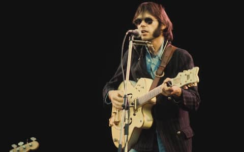 Canadian singer-songwriter Neil Young in concert, circa 1970. (Photo by Michael Putland/Getty Images)