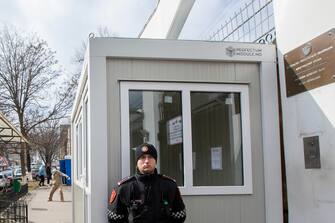 epa11225348 A Carabineri officer (R) stands guard, unaware that a man (L) wearing a mask is preparing to throw a handmade molotov cocktail towards the Russian Embassy in Chisinau, during Russian presidential elections, in Moldova, 17 March 2024. The Russian Federation Council has scheduled presidential elections for 17 March 2024. Voting will last three days: March 15, 16 and 17. Four candidates registered by the Central Election Commission of the Russian Federation are vying for the post of head of state: Leonid Slutsky, Nikolai Kharitonov, Vladislav Davankov and Vladimir Putin.  EPA/DUMITRU DORU