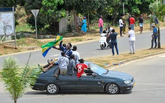 epa10828747 People wave Gabon national flags as they celebrate after a military coup, in the streets of Akanda, Gabon, 30 August 2023. Members of the Gabonese army on 30 August announced on national television that they were canceling the election results and putting an end to Gabonese President Ali Bongo's regime, who had been declared the winner.  EPA/STR