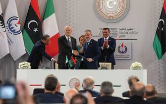 Italian multinational oil and gas company ENI's CEO Claudio Descalzi (front L) and Libyan National Oil Corporation chief Farhat Bengdara (front R) sign a bilateral agreement during a ceremony attended by Italy's Prime Minister Giorgia Meloni (back C) and Libya's Tripoli-based Prime Minister Abdulhamid Dbeibah (back R) in the Libyan capital, on January 28, 2023. - Meloni arrived in the Libyan capital Tripoli for talks on energy as well as the thorny issue of migration, Libyan state media said. (Photo by Mahmud Turkia / AFP) (Photo by MAHMUD TURKIA/AFP via Getty Images)
