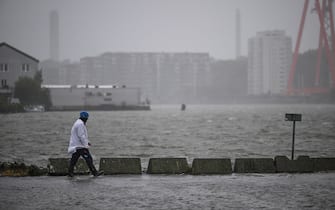A man walks in the flooded area of the fishing port Fiskhamnen where the Gota Alv river overflowed in Gothenburg, Sweden, on August 08, 2023, after heavy rainfalls as a result of the extreme weather "Hans". Sweden's national weather agency SMHI had issued several "yellow alerts" for Monday, warning of strong winds, floods and heavy rains in multiple parts of the country as extreme weather "Hans" moved in across the country over the weekend. (Photo by Bjorn LARSSON ROSVALL / TT News Agency / AFP) / Sweden OUT (Photo by BJORN LARSSON ROSVALL/TT News Agency/AFP via Getty Images)