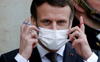PARIS, FRANCE - FEBRUARY 14: French President Emmanuel Macron takes off his protective face mask as he welcomes Tanzania's President Samia Suluhu prior to a meeting at the Elysee Palace on February 14, 2022 in Paris, France. The official announcement of Emmanuel Macron's candidacy for the 2022 presidential election is eagerly awaited by a large number of French people. According to an Ifop poll for Le Figaro and LCI, the head of state is now credited with 25% of voting intentions, far ahead of the other candidates. (Photo by Chesnot/Getty Images)