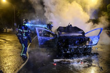 Firefighters extinguish a car that caught fire in Nantes, western France on early July 1, 2023, four days after a 17-year-old man was killed by police in Nanterre, a western suburb of Paris. French President Emmanuel Macron has announced measures including more police and urged parents to keep minors off the streets as he battled to contain nightly riots over a teenager's fatal shooting by an officer in a traffic stop. (Photo by Sebastien SALOM-GOMIS / AFP) (Photo by SEBASTIEN SALOM-GOMIS/AFP via Getty Images)