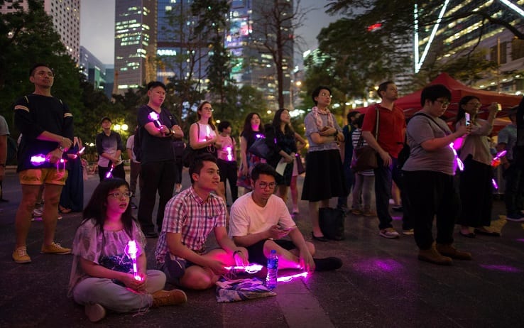 epa07578380 A LGBT (lesbian, gay, bisexual, and transgender) supporter holds the rainbow flag during an evening of solidarity for International Day Against Homophobia, Transphobia and Biphobia 2019 in Hong Kong, China, 17 May 2019.  EPA/JEROME FAVRE