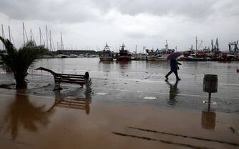 epa10843203 A man walks through a flooded road during the storm named Daniel in the area of Volos, Magnesia, Greece, 06 September 2023. The storm 'Daniel' sweeping through most of Greece with heavy rain and lightning caused extensive damage in the power network at Volos, Mt. Pilio, elsewhere in the Magnissia prefecture, as well as in the Sporades Islands.  EPA/YANNIS KOLESIDIS