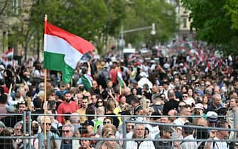 A participant displays the Hungarian flag during a rally organised by Hungarian opposition figure Peter Magyar, Hungarian lawyer, former government insider and ex-husband of former Justice Minister Varga, in downtown Budapest on April 06, 2024, to denounce the Hungarian government and corruption. (Photo by Attila KISBENEDEK / AFP)