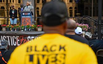 epa09224568 Rev. Al Sharpton  (R) speaks to hundreds of supporters as he shares the stage with Attorney Ben Crump (C) and Bridgett Floyd (L), sister of George Floyd, at a rally in Minneapolis, Minnesota, USA, 23 May 2021. The rally is  part of several days of events to commemorate the anniversary of George Floyd's death which sparked the Black Lives Matter movement around the world.  EPA/CRAIG LASSIG