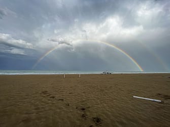 A circular rainbow is visible on the beach with a small boat in Tortoreto Lido, in the province of Teramo, Abruzzo, Italy, on April 25th, 2023. (Photo by Andrea Mancini/NurPhoto via Getty Images)
